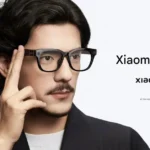 Official promo image of Xiaomi AI Glasses with man tapping the frame to activate XiaoAi assistant
