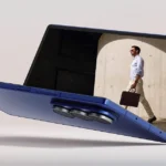 Samsung Galaxy Z Fold 7 in blue, half-open with screen showing a man walking, highlighting the foldable display and triple camera design